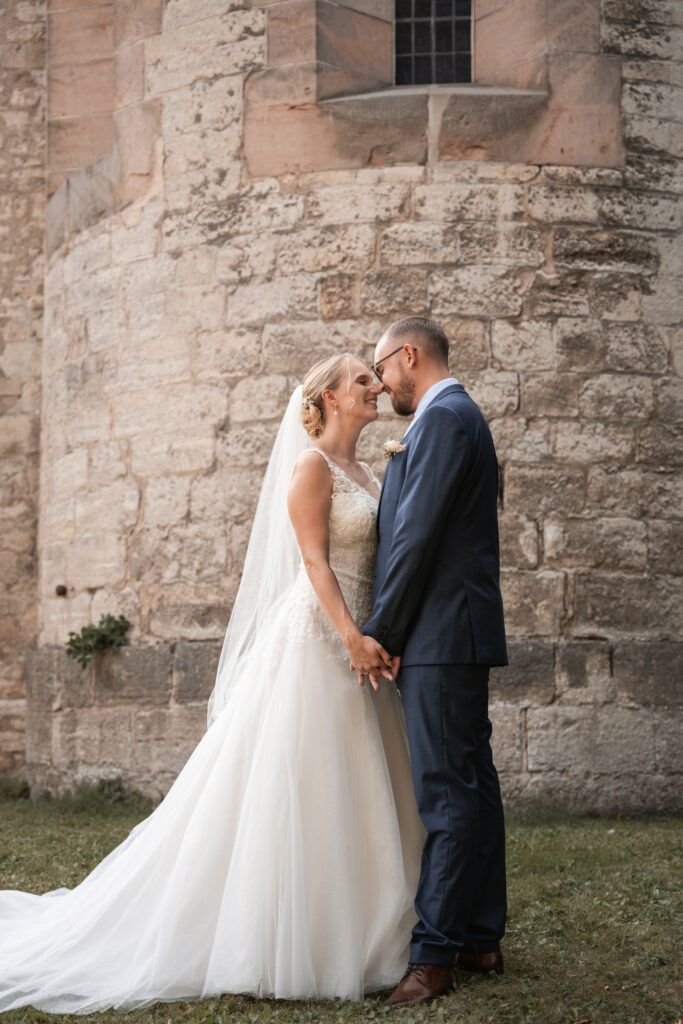 Intimer Moment des Brautpaares beim Shooting vor der Kirche